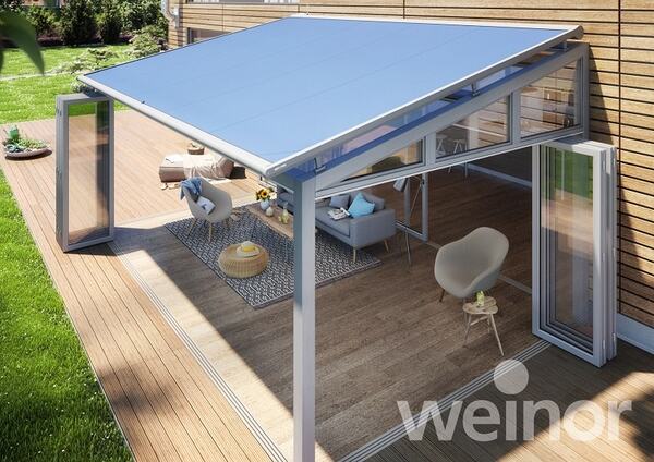 Moderne Terrassenüberdachung aus Glas und Aluminium mit stilvoller Outdoor-Sitzgruppe.